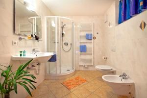 a bathroom with a shower and two sinks and a toilet at Wurzerhof in Racines