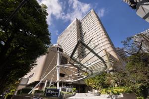 un grand bâtiment avec un escalier en colimaçon devant lui dans l'établissement Hotel Metropolitan Tokyo Ikebukuro, à Tokyo
