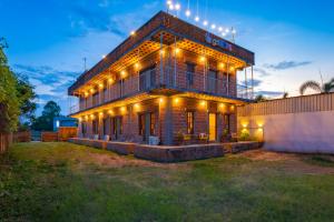 a house with lights on the side of it at goSTOPS Pondicherry Near Auroville in Auroville