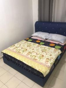 a bed with a blue frame with a quilt on it at Maryam kiara kerteh homestay in Kertih