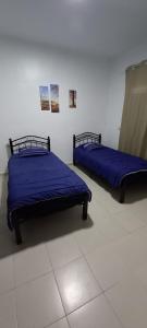twee bedden met blauwe lakens in een kamer bij Magnifique Villa Al Cudia Smir vue Mer Fnideq / Mdiq in Fnidek