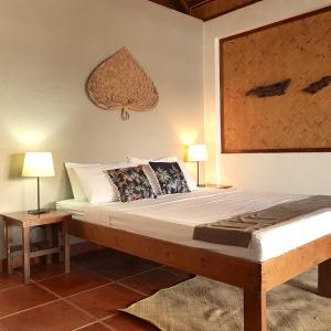 愛妮島的住宿－Golden Monkey Beach Hotel，一间卧室配有一张大床和两盏灯