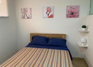 1 cama en un dormitorio con pinturas en la pared en Acogedor departamento amoblado en san miguel, primer piso, wifi., en Lima
