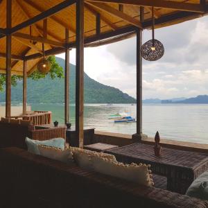 a bar with a view of a body of water at Golden Monkey Beach Hotel in El Nido