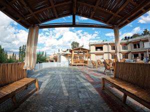 un ampio patio esterno con panchine e un edificio di Cho Palace a Leh