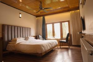 a bedroom with a large bed and a ceiling fan at Cho Palace in Leh