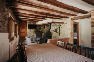 a dining room with a table and a fireplace at Can Roca Rural in Sant Joan de les Abadesses