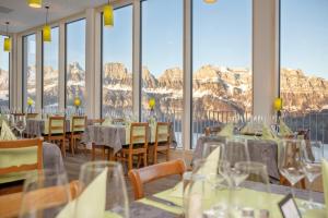 a restaurant with tables and chairs with mountains in the background at Ferienwohnungen Tannenboden in Flumserberg