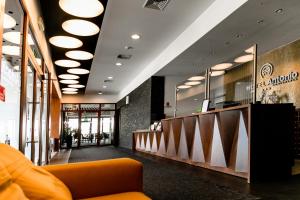a lobby of a restaurant with an orange couch at Hotel Antonio Conference in Brzeg