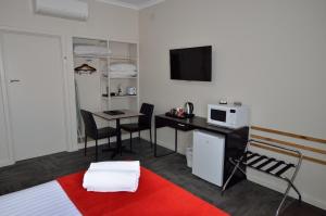 a room with a kitchen and a desk and a microwave at 105 On The Park in Bordertown