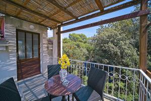 a table with a vase of flowers on a balcony at Guest House Matana Pomena in Pomena