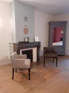 a living room with a chair and a fireplace at Moulin Chantepierre in Pont-dʼHéry