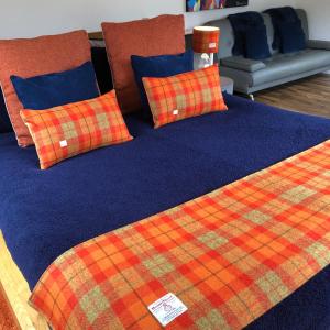 two beds with plaid pillows on top at Drovers Studio Apartment in Tomatin