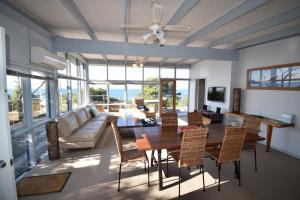 a living room with a table and chairs and a couch at Wamoon Views Waratah Bay in Walkerville