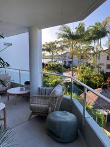 Un balcón con una silla y vistas al océano. en Munna Beach Apartments, en Noosaville