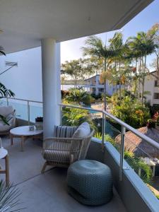 a balcony with a chair and a view of the ocean at Munna Beach Apartments in Noosaville