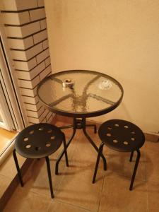 a glass table and two stools sitting next to a table at Apartment Andjela in Belgrade