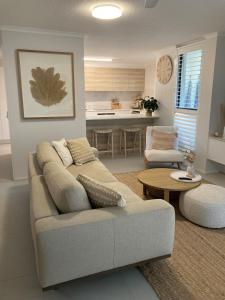 a living room with a couch and a table at Munna Beach Apartments in Noosaville