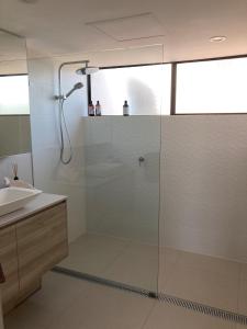 een badkamer met een douche en een wastafel bij Munna Beach Apartments in Noosaville