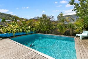 una piscina con terrazza in legno e sedia bianca di Seaview Apollo Escape - BYO Linen a Apollo Bay