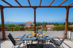 a table and chairs on a balcony with a view at Villa Erasmia- House 2 upper floor in Sarláta