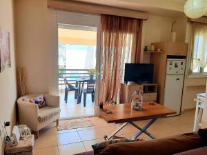 a living room with a couch and a table and a kitchen at Central Square appartment with panoramic view in Kalamata
