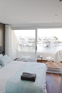 a bedroom with a bed and a view of a marina at Marina NS Guesthouse in Le Grau-du-Roi