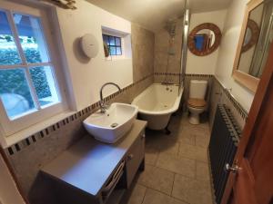 a bathroom with a sink and a tub and a toilet at Shore Thing - Just a stones throw from the beach in Sandgate