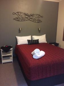 a hotel room with a bed with two towels on it at Benalla Apartments in Benalla