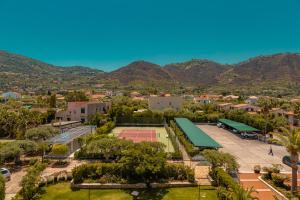 an aerial view of a tennis court with mountains in the background at Hotel Baia Del Capitano in Cefalù