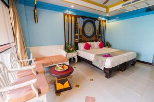 a bedroom with a bed and a couch and a table at Ayodhaya Palace Beach Resort-Family run -SHA Plus certified in Ao Nang Beach