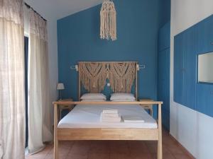 Habitación azul con cama con pared azul en Lontos Village, en Finikounta