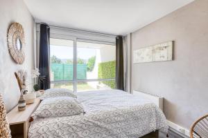 a bedroom with a bed and a large window at L'éclat Verdoyant de Noisy - Jardin in Noisy-le-Grand