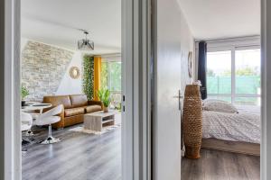1 dormitorio con 1 cama y sala de estar en L'éclat Verdoyant de Noisy - Jardin, en Noisy-le-Grand