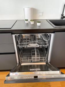 an open dishwasher with three plants in it at Penthouse Kadriorg in Tallinn