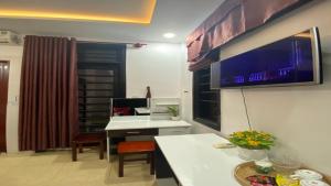 a room with a desk and a tv on the wall at Hue Happy Homestay in Hue