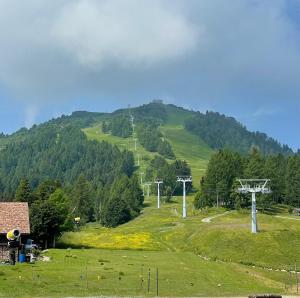 a green hill with trees and a field with turbines at Hotel Enzo Moro in S&ugrave;trio