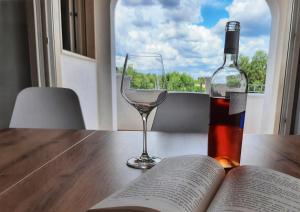 una botella de vino y una copa de vino en una mesa en Shekhinah Bed and Breakfast Home Restaurant, en Maruggio