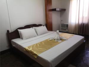 a bedroom with a bed with a robe on it at OYO 880 Flores De Musa Inn in Puerto Princesa City