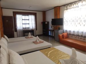 a living room with two beds and a couch at OYO 880 Flores De Musa Inn in Puerto Princesa City