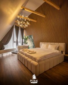 Schlafzimmer mit einem Bett und einem Kronleuchter in der Unterkunft Pine Villas Brezovice in Brezovica