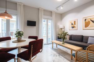 ein Wohnzimmer mit einem Tisch und einem Sofa in der Unterkunft Magno Apartments Guadalquivir Terrace in Sevilla