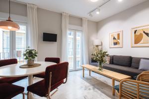 salon ze stołem i kanapą w obiekcie Guadalquivir Terrace Suite Apartments w Sewilli