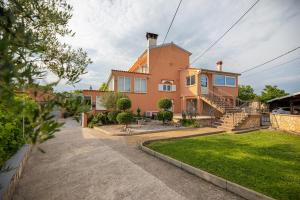 a house with a staircase in front of a yard at Apartment Josip Brusic in Gabonjin