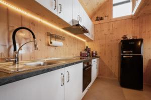 a kitchen with a sink and a black refrigerator at Bergspektive - Haus Alpenspa in Rieding