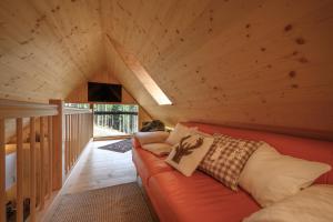a living room with an orange couch in a attic at Bergspektive - Haus Alpenspa in Rieding