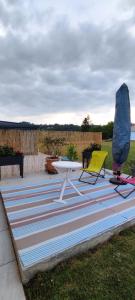 une table de pique-nique et deux chaises sur un tapis rayé dans l'établissement Montignac lascaux chambre, à Montignac