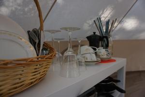 a shelf with plates and glasses and a basket on it at Pigna Felice Punta Ala in Punta Ala