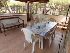un tavolo e sedie seduti su un patio di La Perla al mare 300mt from Perla Marina Beach a Santa Margherita di Pula