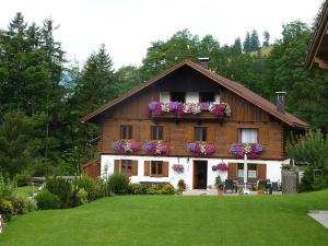 una casa con flores en la parte delantera en Ferienwohnungen Durst Roswitha, en Schattwald